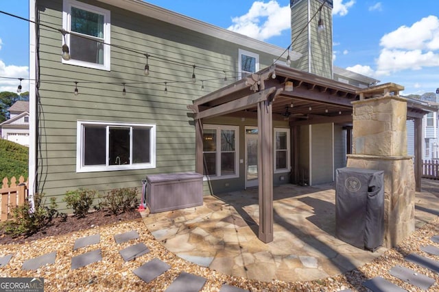 back of property with a patio area, a chimney, and fence