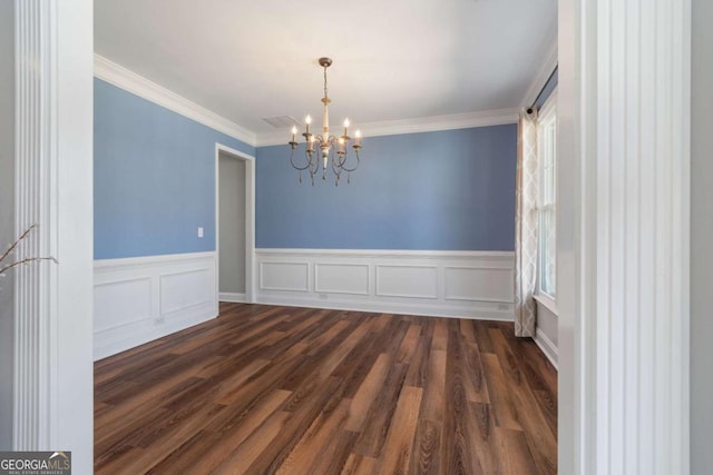 unfurnished dining area featuring dark wood-style floors, a chandelier, and crown molding