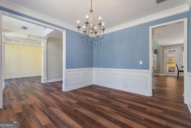 unfurnished dining area featuring dark wood finished floors, crown molding, visible vents, and a chandelier