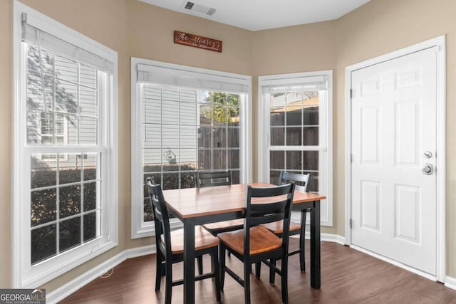 dining room featuring dark wood-type flooring, baseboards, and visible vents