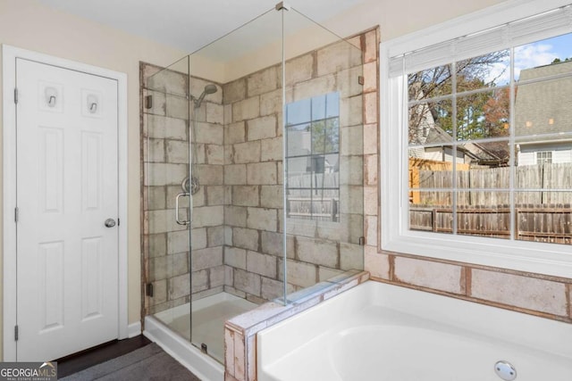 bathroom featuring a stall shower and a bath