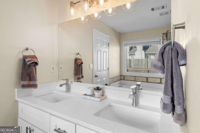 bathroom with double vanity, visible vents, and a sink