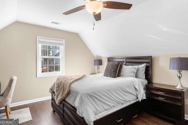 bedroom featuring visible vents, baseboards, dark wood-style floors, and vaulted ceiling