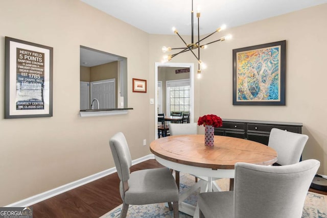 dining room with baseboards, wood finished floors, and a chandelier