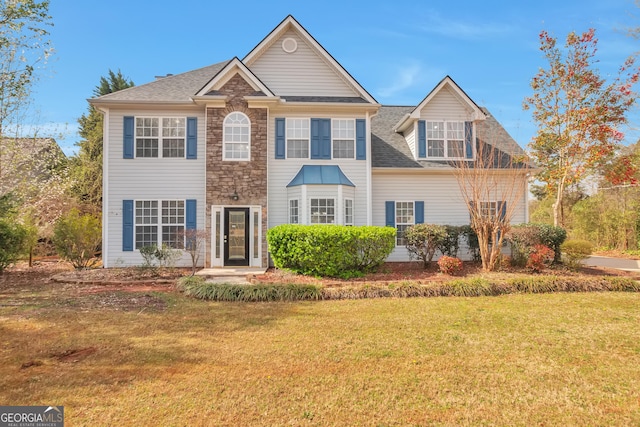 colonial inspired home featuring a front lawn