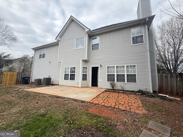 rear view of house featuring cooling unit, fence, a chimney, and a patio area