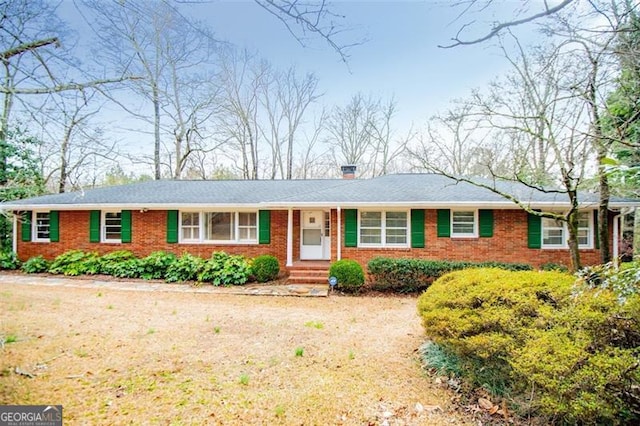 ranch-style home with brick siding and a chimney