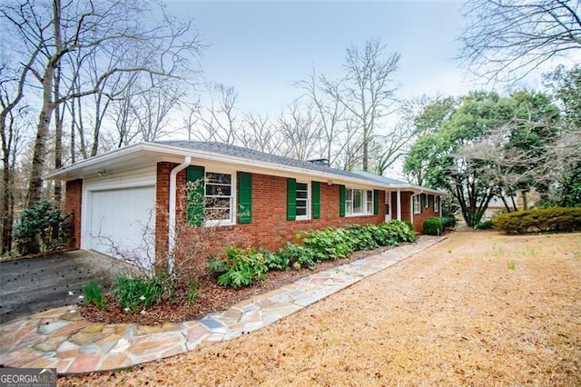 ranch-style house featuring brick siding, concrete driveway, and a garage