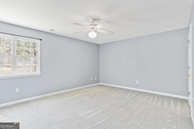 carpeted empty room featuring a ceiling fan, baseboards, and a textured ceiling