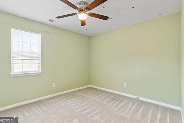 unfurnished room with visible vents, light carpet, and baseboards