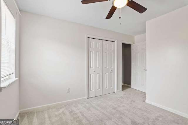 unfurnished bedroom featuring carpet flooring, a ceiling fan, baseboards, and a closet