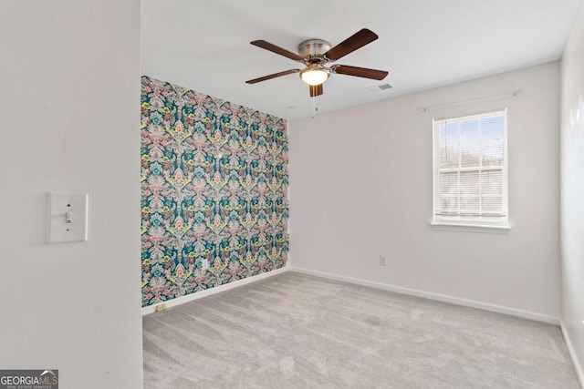 carpeted empty room featuring a ceiling fan, baseboards, and visible vents