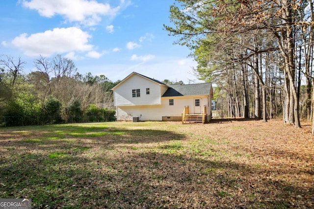 back of house with crawl space, a lawn, and central AC