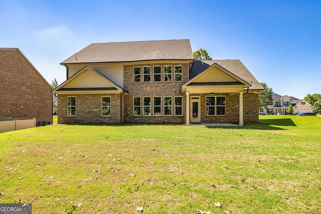 back of property featuring a yard, a patio, brick siding, and fence