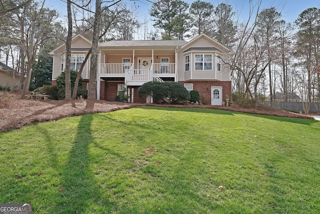 view of front of home featuring brick siding, a porch, and a front lawn