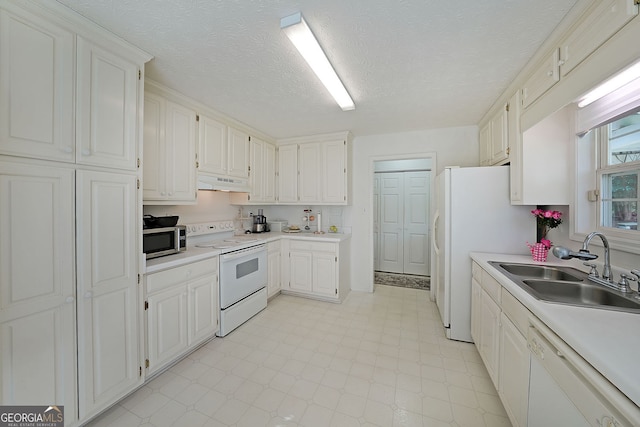 kitchen featuring white appliances, light floors, a sink, light countertops, and under cabinet range hood