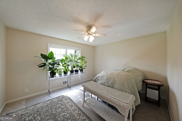 bedroom with visible vents, a ceiling fan, baseboards, and a textured ceiling