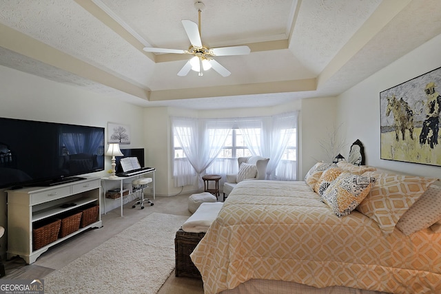 carpeted bedroom featuring a raised ceiling, a ceiling fan, and a textured ceiling