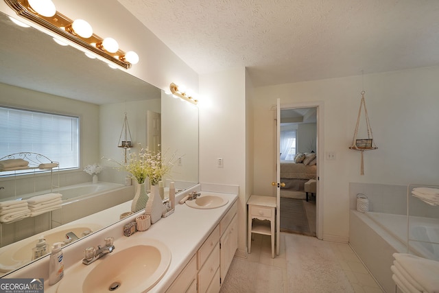 full bathroom with a bath, double vanity, and a sink