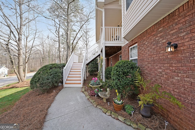 view of side of home featuring stairs and brick siding