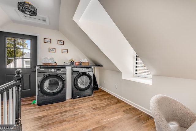 clothes washing area with laundry area, wood finished floors, baseboards, and washer and clothes dryer