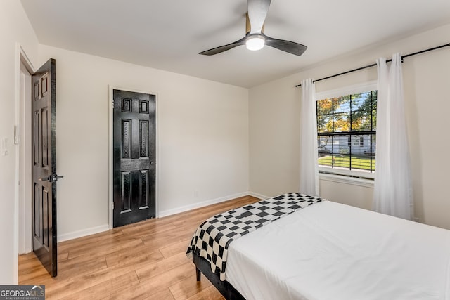 bedroom featuring baseboards, a ceiling fan, and light wood finished floors