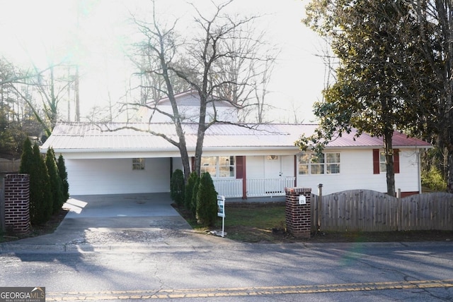 single story home with cooling unit, fence, driveway, covered porch, and metal roof