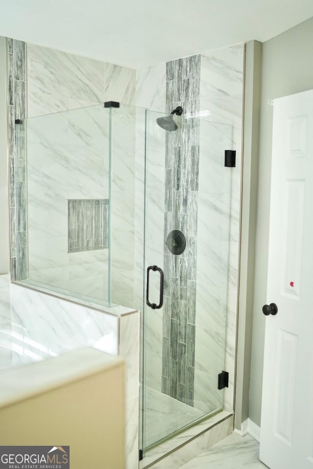 bathroom featuring a marble finish shower and marble finish floor