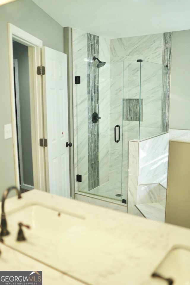 full bathroom featuring vanity and a marble finish shower