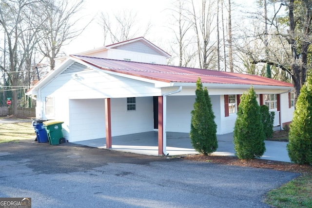 view of front of house with aphalt driveway and metal roof