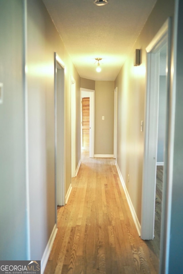 hallway with baseboards and light wood finished floors