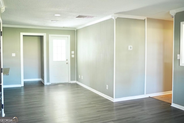 spare room featuring dark wood finished floors, visible vents, and ornamental molding