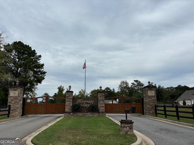 view of road with a gated entry, curbs, and a gate