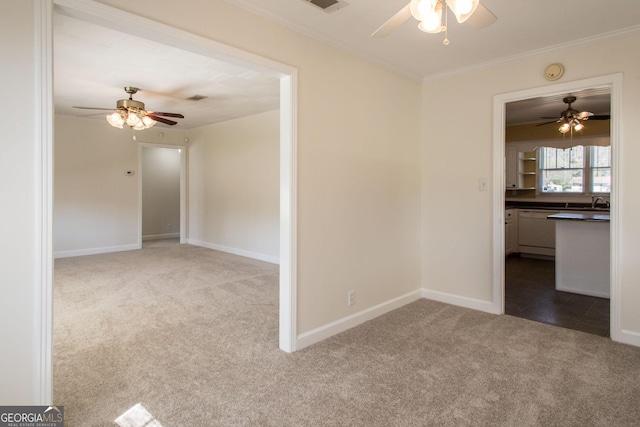 unfurnished room with baseboards, a ceiling fan, ornamental molding, and carpet flooring