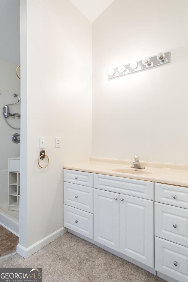 full bath featuring vanity, a shower, and baseboards