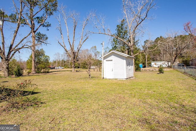 view of yard with an outdoor structure, fence, and a shed