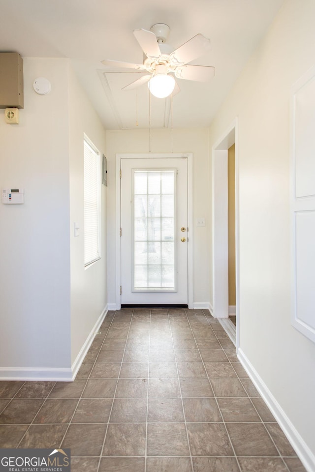 entryway featuring tile patterned flooring, a ceiling fan, and baseboards