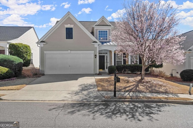 traditional-style home featuring an attached garage, driveway, metal roof, and a standing seam roof