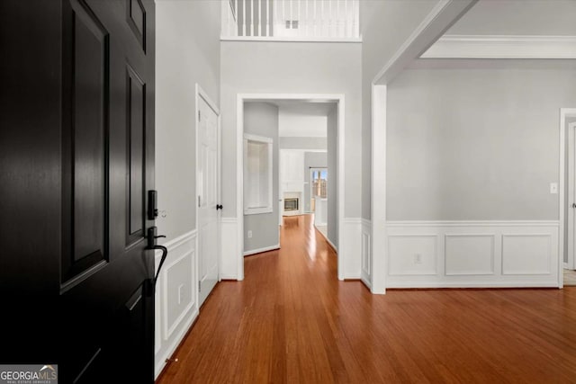 entryway with crown molding and wood finished floors