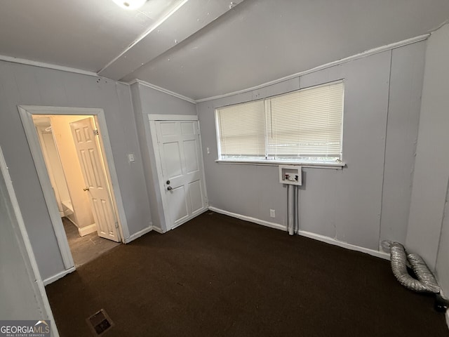 unfurnished bedroom with visible vents, dark carpet, baseboards, and lofted ceiling