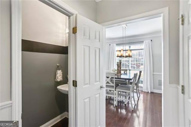 bathroom featuring baseboards, wood finished floors, and a chandelier