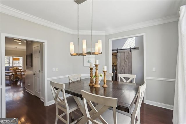 dining area featuring ornamental molding, baseboards, a barn door, and wood finished floors