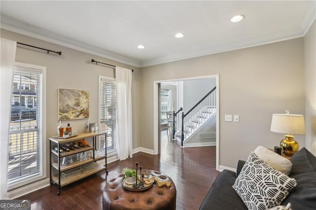 living area with stairway, wood finished floors, baseboards, and ornamental molding