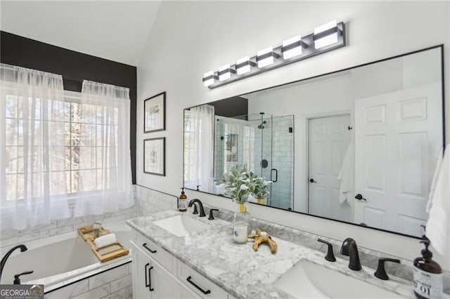 full bath with a sink, lofted ceiling, a stall shower, and double vanity