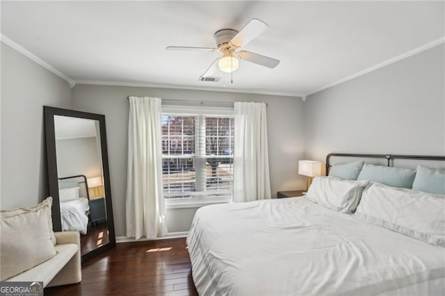 bedroom with visible vents, crown molding, baseboards, ceiling fan, and dark wood-style flooring