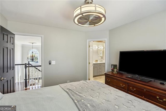 bedroom with light wood finished floors and ensuite bathroom