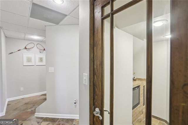 bathroom with a drop ceiling and baseboards