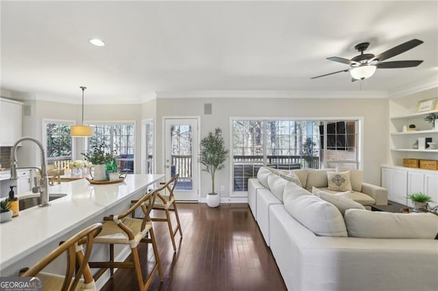 living room featuring ceiling fan, dark wood-type flooring, recessed lighting, and ornamental molding