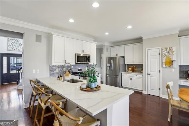 kitchen featuring white cabinetry, ornamental molding, appliances with stainless steel finishes, and a sink