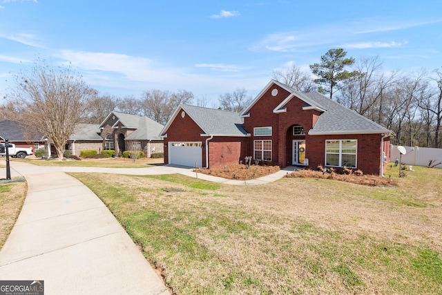 traditional-style house featuring fence, roof with shingles, a front lawn, concrete driveway, and brick siding